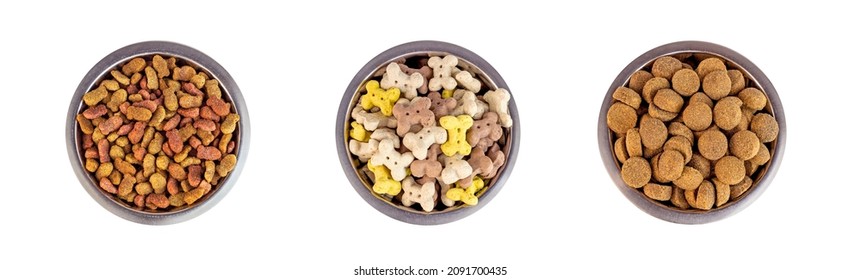 Top view of brown biscuit bones and crunchy organic kibble pieces for dog feed in a metal bowl set isolated on white background. Healthy dry pet food