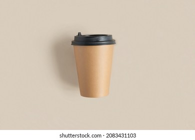 Top view of a Brown coffee paper cup. Mockup with lid. Set of craft paper cups for coffee or tea on beige background. Flat lay. Zero waste, plastic free concept. Disposable Recycled cups.