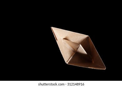 Top View Of A Brown Origami Paper Boat On Black Background.