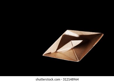 Top View Of A Brown Origami Paper Boat On Black Background.