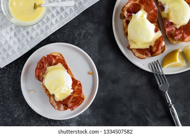 Top View Of Bruschetta With Parma Ham And Egg Benedict. Classic Eggs Benedict With Bacon, Hollandaise Sauce, View From Above