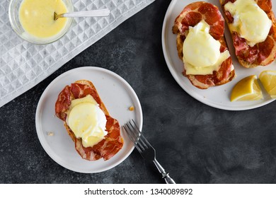 Top View Of Bruschetta With Parma Ham And Egg Benedict. Classic Eggs Benedict With Bacon, Hollandaise Sauce, View From Above