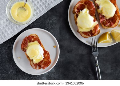 Top View Of Bruschetta With Parma Ham And Egg Benedict. Classic Eggs Benedict With Bacon, Hollandaise Sauce, View From Above