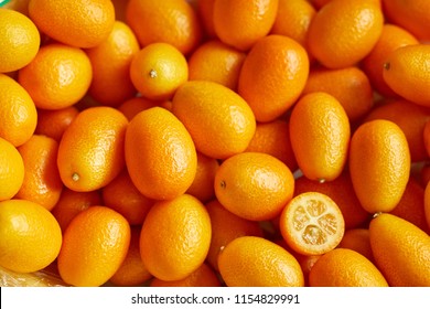 Top view of bunch of fresh kumquats in the organic food market. Some kumquats is cutted