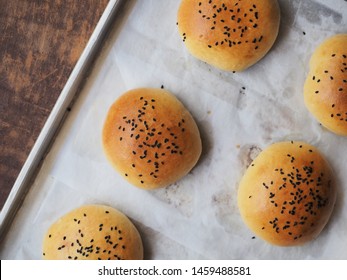 Top View Burger Bun Topped With Black Sesame Seed On Baking Tray. 