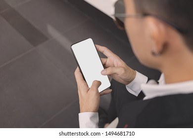 Top View Of The Business Man  In A Black Suit Are Watching Mobile Phones With White Screens. Bird Eye View Of The Asian Man Are Pressing The Phone Screen.