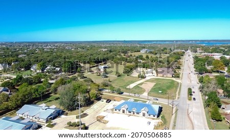 Top view business park along Kimball Avenue toward Grapevine Lake, Texas. Row of lakeside commercial buildings and residential houses with mature trees