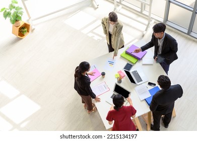 Top View Of Business People Group Meeting In Office. Aerial View With Professional Businesswomen And Businessmen Working In Team Conference With Project Planning Document On The Meeting Table