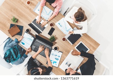 Top View Of Businessman Executive In Group Meeting With Other Businessmen And Businesswomen In Modern Office With Laptop Computer, Coffee And Document On Table. People Corporate Business Team Concept.