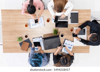 Top View Of Businessman Executive In Group Meeting With Other Businessmen And Businesswomen In Modern Office With Laptop Computer, Coffee And Document On Table. People Corporate Business Team Concept.