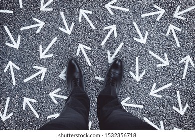 Top view of businessman feet with arrows on concrete background. Different direction and choice concept  - Shutterstock ID 1532356718