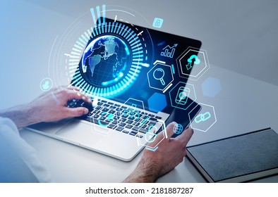 Top view of businessman hands with phone and laptop on office desk. Earth sphere with worldwide connection hologram, icons hud menu. Concept of global internet