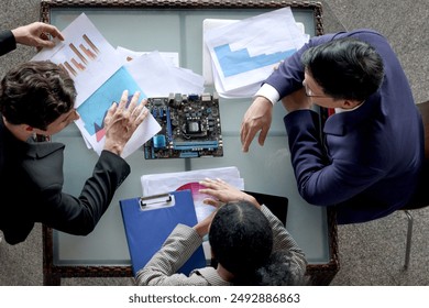 Top view of businesspeople group meeting together at office workplace. Business partnership colleague coworker discussing about circuit commuter board and brainstorming for new project work.  - Powered by Shutterstock