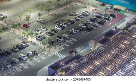 Top View Busy Parking Lot With Many Cars Moving In And Out Night Timelapse. Aerial View From Above With Some Taxi Near Shopping Mall