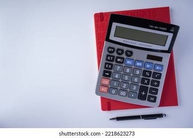 Top View Calculator With Red Book And Black Pen Isolated With White Background