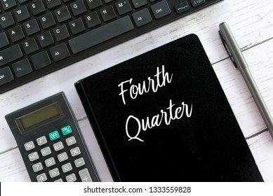 Top View Of Calculator,keyboard,pen And Notebook Written With Fourth Quarter.