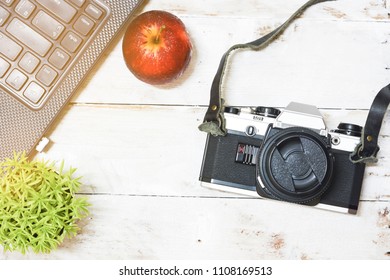 Top view camera placed on a white wooden table.