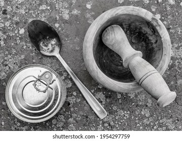 Top view of a can of packaged food, a wooden mortar and a metal spoon on a spotted background, in black and white - Powered by Shutterstock