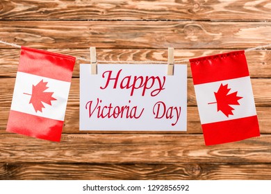 top view of canadian flags and card with 'happy victoria day' lettering on wooden background - Shutterstock ID 1292856592