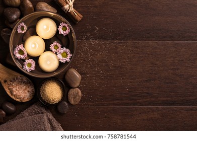 Top View Of Candles With Salt And Pebbles On Wooden Background With Copy Space. Burning Candle In Water With Flowers, Rock Salt And Towels At Luxury Spa. High Angle View Of Aromatherapy Set At Salon.