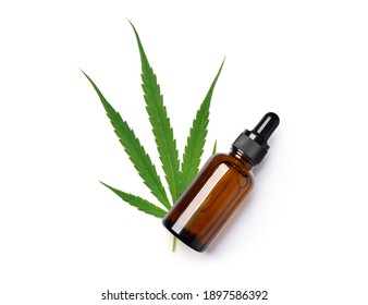 Top View Of Cannabis Essential Oil In Dropper Bottle With Green Leaf On White Background.