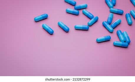 Top View Capsule Pills On Pink Background. Prescription Drugs. Blue Capsule Pills. Pharmaceutical Industry. Medicament And Pharmacology. Drug Development And New Drug Research. Capsule Pills Industry.