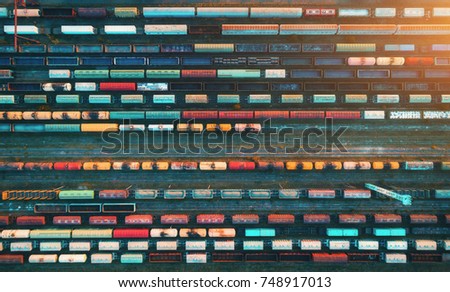 Top view of cargo trains. Aerial view from flying drone of colorful freight trains on the railway station. Wagons with goods on railroad. Heavy industry. Industrial conceptual scene with trains.
