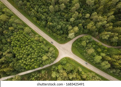 Top View Of Cars Driving On Road With Intersection Through Forest