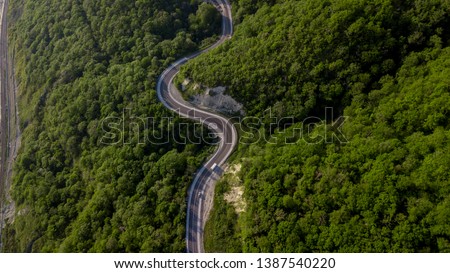 Top view of cars driving on zig zag winding mountain road