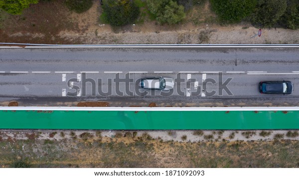 Top view of cars driving on an asphalt road on the\
Atlantic coast of Cadiz, south Spain. Aerial drone top view from\
above of a road