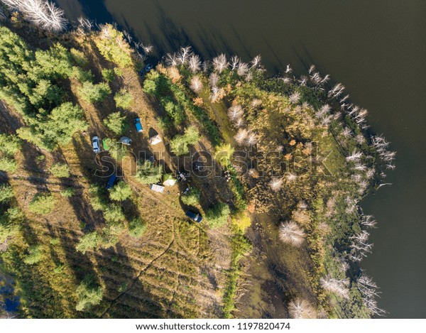 Top view cars stand in the\
forest near the lake, top view, Top view aerial photo from\
drone.