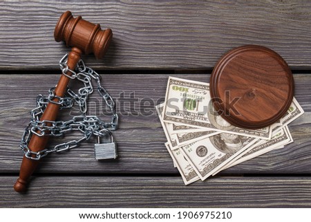 Top view chained gavel and dollars. Concept of bribe and corruption in a court.