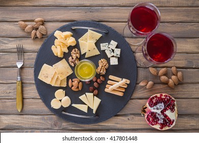 Top view cheese plate Assortment of various types of cheese on dark slate cutting board - Powered by Shutterstock