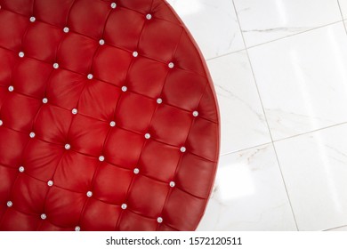 Top View Of A Chic Red Round Sofa With Shiny Buttons. Luxurious Design Of Upholstered Furniture.