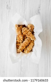 Top View Chicken Fingers In Paper Box On A White Wooden Table. Flat Lay, From Above, Overhead. Close-up.