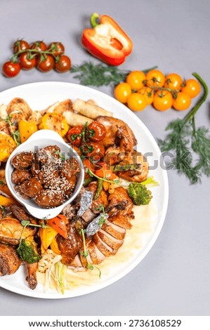 Top view of chicken platter with vegetables sauces and decorative elements on grey background