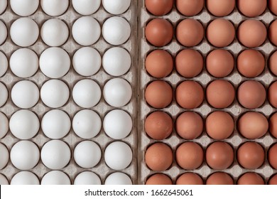 top view chicken raw eggs of yellow and white color lying in carton recyclable cardboard box, natural pattern and concept of spring and easter, close-up