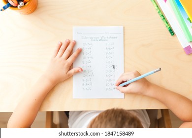 Top View Of Child Hands With Pencils. Solving Maths Exercises. 7 Years Old Child Doing Maths Lessons Sitting At Desk In His Room.