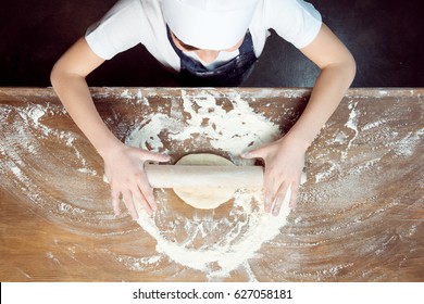 Top View Of Child Making Pizza Dough On Wooden Tabletop