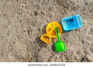 Top view of children's beach toys on sand on a sunny day - Powered by Shutterstock