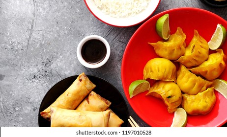 Top view of Chinese food set. Dumplings, boiled rice, spring rolls, fortune cookies on stone table. - Powered by Shutterstock