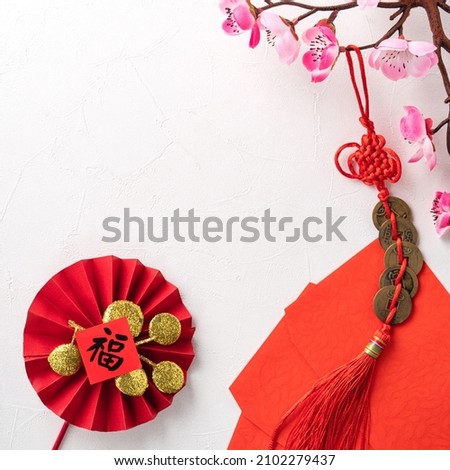 Top view of Chinese lunar new year background copy space design concept with pink plum blossom and festive decoration, the word inside picture means blessing.