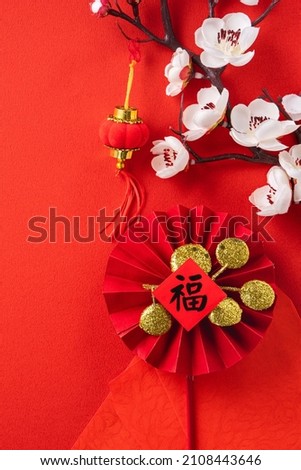 Top view of Chinese lunar new year background copy space design concept with red plum blossom and festive decoration, the word inside picture means blessing.