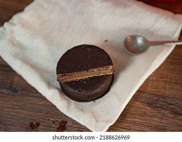 A Top View Of A Chocolate Caramel Cookie And A Half On Top, On A Cloth Napkin, On A Wooden Table