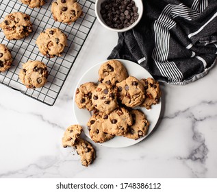 Top View Of Chocolate Chip Cookies On A Plate On White Marble Counter.