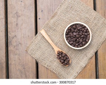 Top view -  Chocolate chips in wooden spoon and bowl on  burlap hessian sacking - Powered by Shutterstock