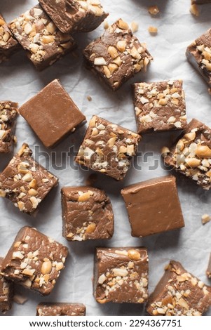 Top view of chocolate fudge with nuts on a marble board, chocolate fudge cut into pieces, fudge candy on a chopping board