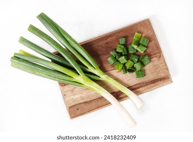 Top view of chopped leek on the wooden cutting board. Isolated on white background with copy space. Cooking concept. 