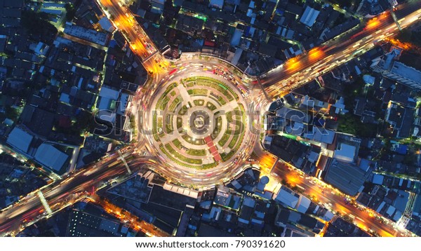 Top view city , Aerial view road , Expressway with car\
lots in the city in Thailand. Beautiful Street at downtown.Road\
roundabout 