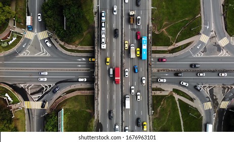 Top view of a city intersection with buses, cars, trucks. Traffic at daytime, roadcross in the megapolis. Going forward with cars.